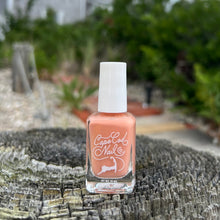 Load image into Gallery viewer, A bottle of nail polish with an orange undertone color, placed on a wooden surface with nature in the background.