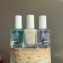 Load image into Gallery viewer, Three bottles of nail polish labeled 'CAPE COD NAIL CO.', set on top of a wooden surface, with colors including clear blue base coat, pearl, and clear top coat.